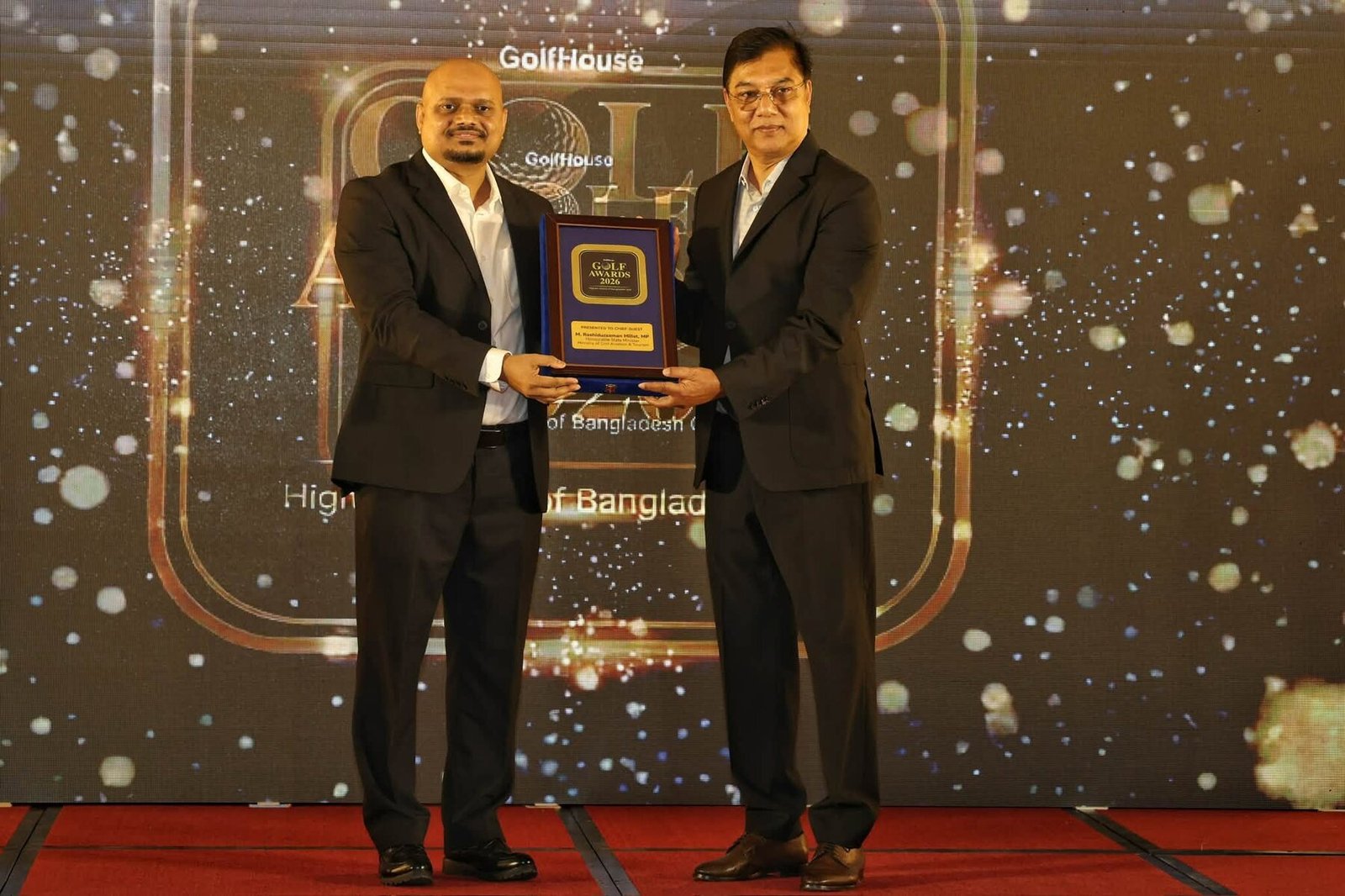 Nazrul Hosen presenting a recognition plaque at an event